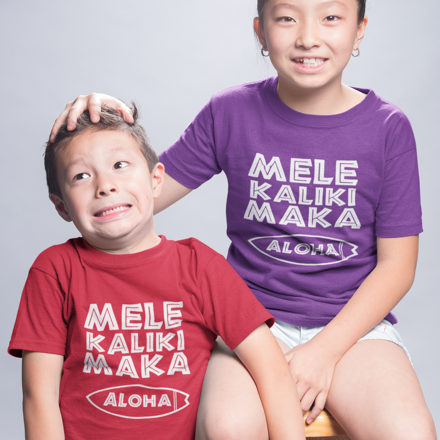 Kids Mele Kalikimaka Christmas T-Shirt with a surfboard hibiscus graphic perfect for holiday celebrations. Holiday Gift Idea! 