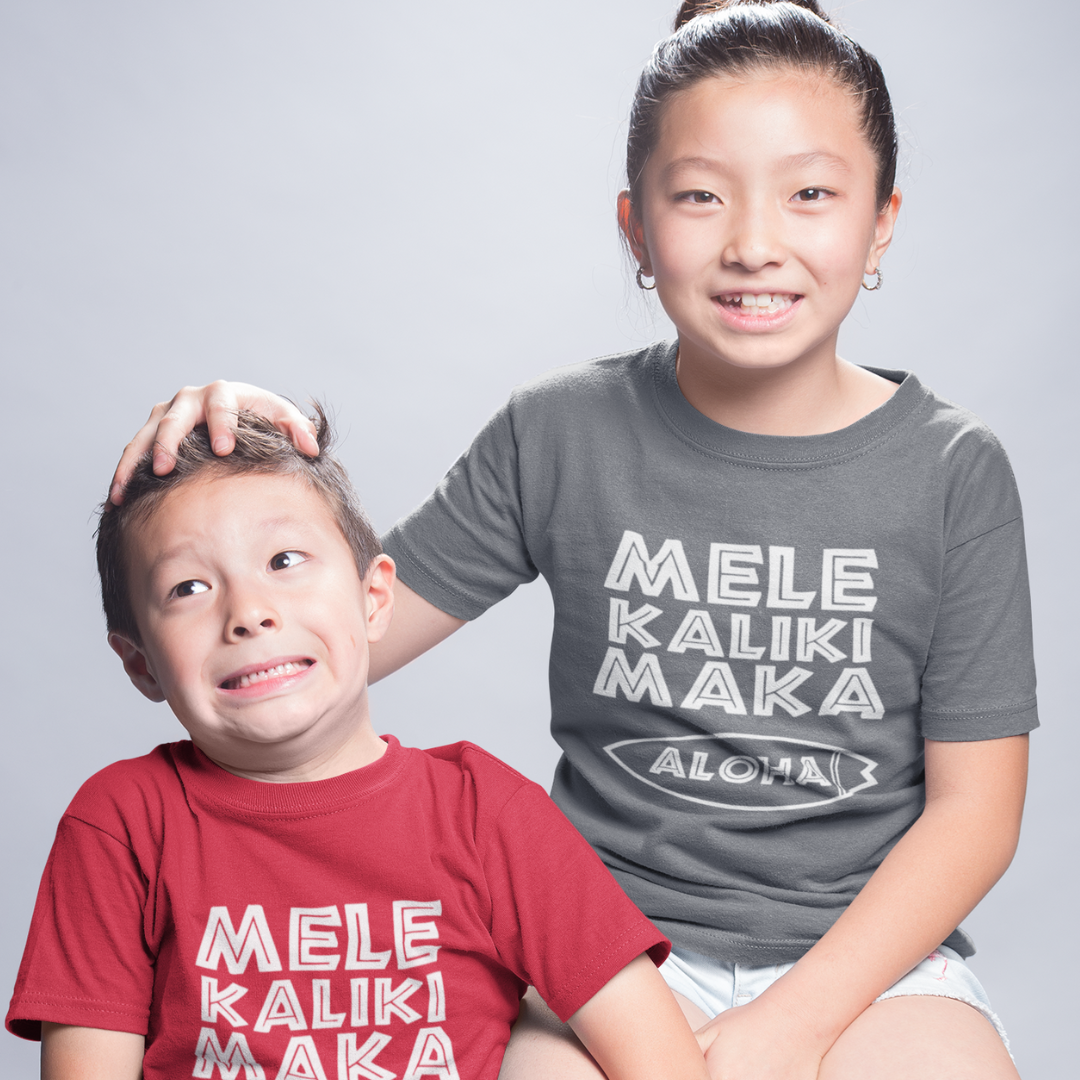 Kids Mele Kalikimaka Christmas T-Shirt with a surfboard hibiscus graphic perfect for holiday celebrations. Holiday Gift Idea! 