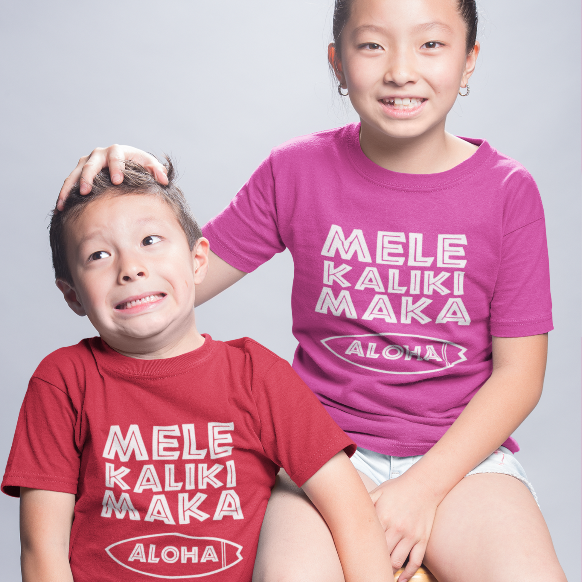 Kids Mele Kalikimaka Christmas T-Shirt with a surfboard hibiscus graphic perfect for holiday celebrations. Holiday Gift Idea! 