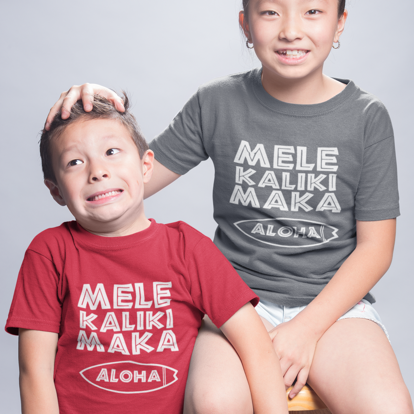 Kids Mele Kalikimaka Christmas Grey T-Shirt with a surfboard hibiscus graphic perfect for holiday celebrations. Holiday Gift Idea! 